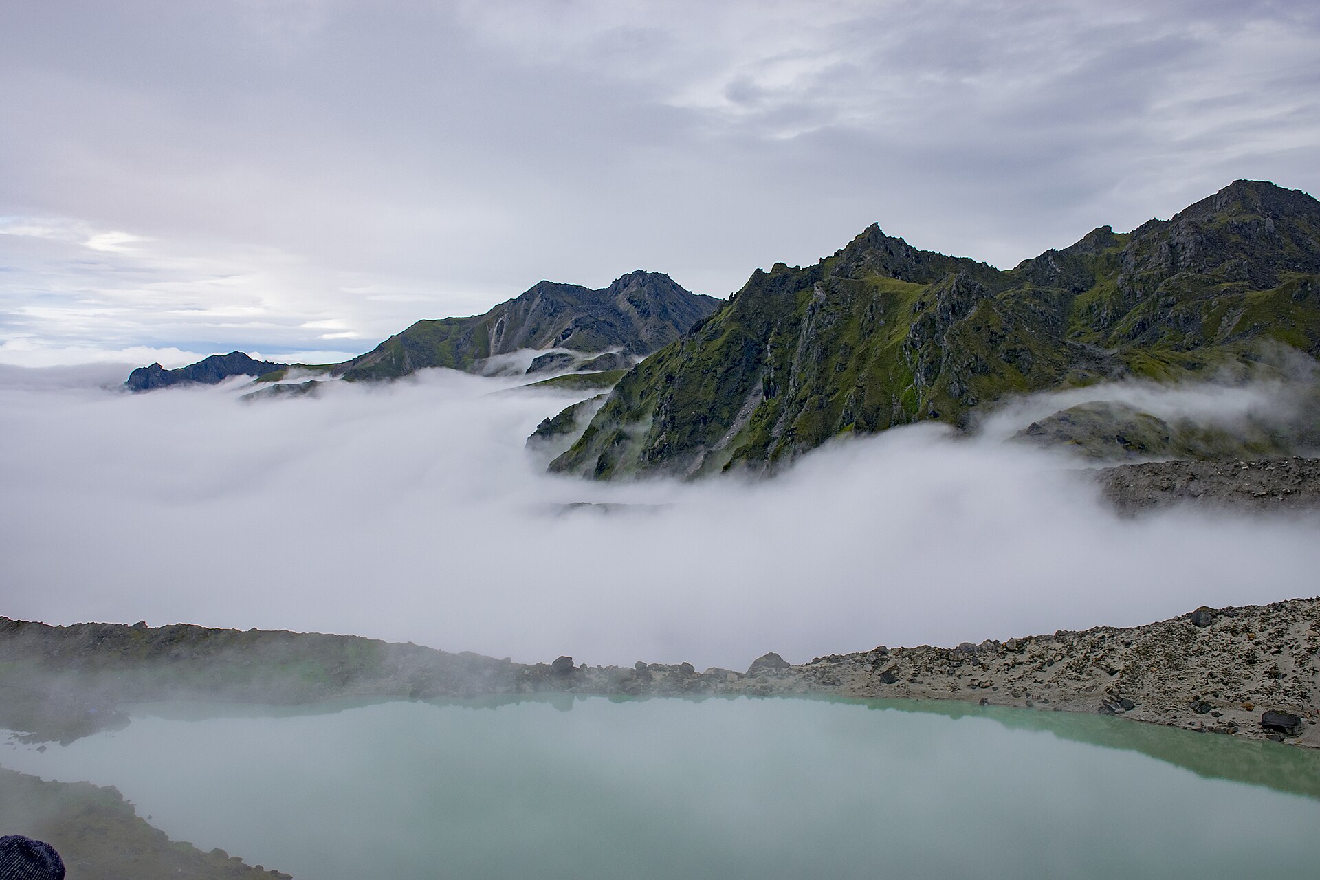 Turquoise water and cloud-covered mountain ridges at Dudh Kunda in Solukhumbu