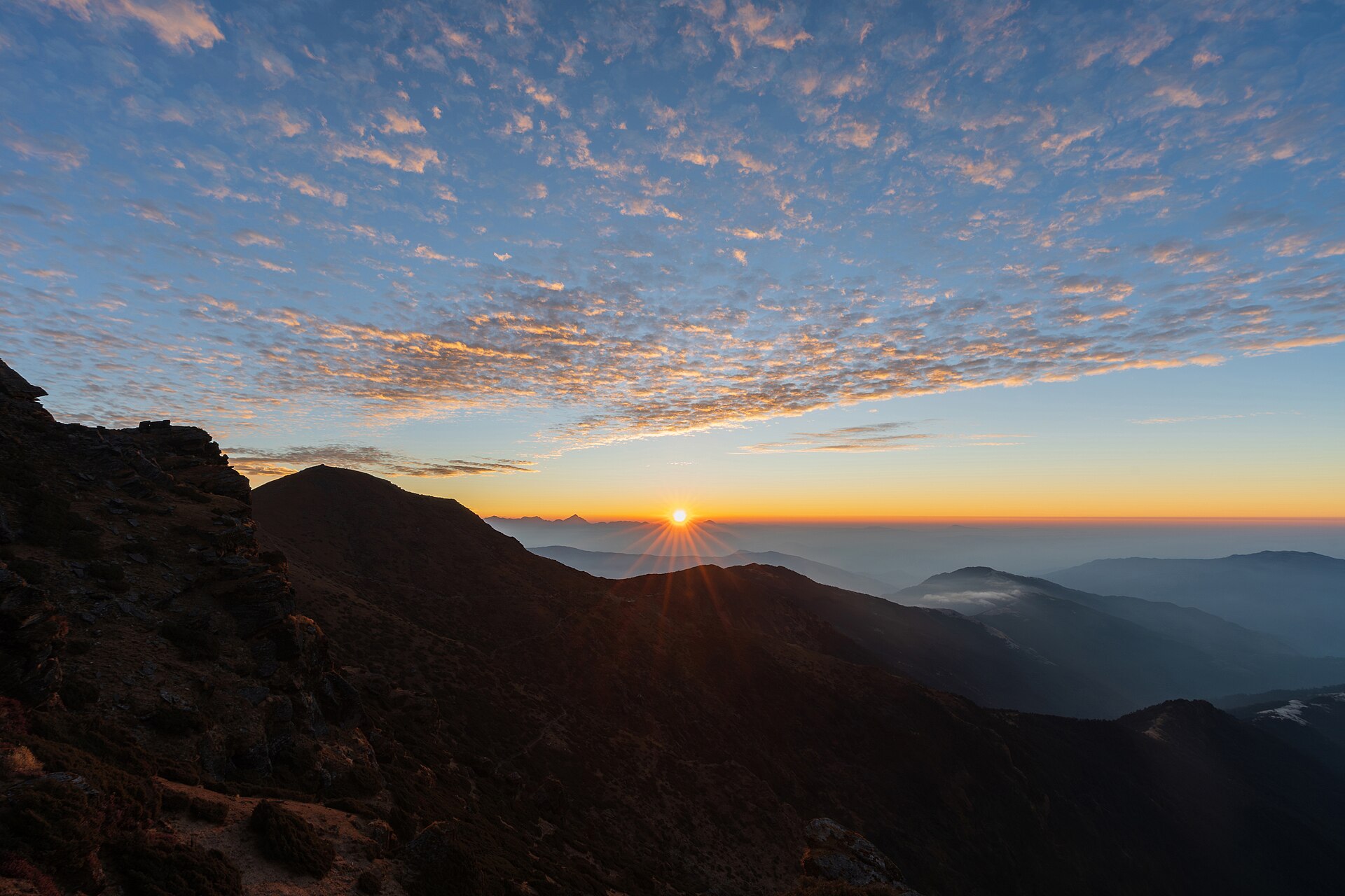 Sunrise over layered Himalayan ridges viewed from Pikey Peak in Solukhumbu