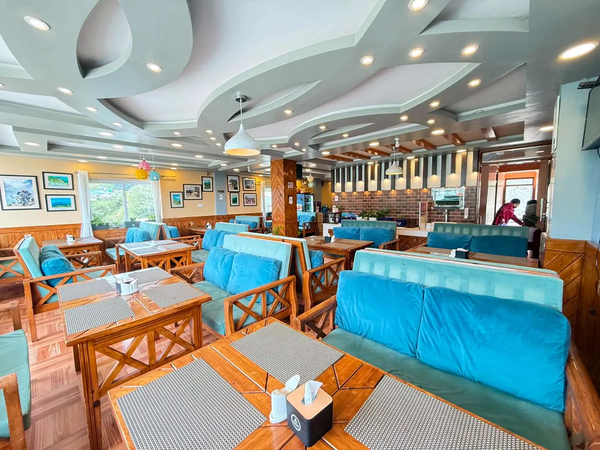 Bright restaurant with wooden tables and blue upholstered seating