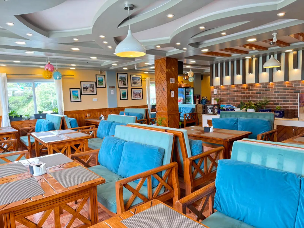 Hotel restaurant with blue seating, timber tables, and natural light